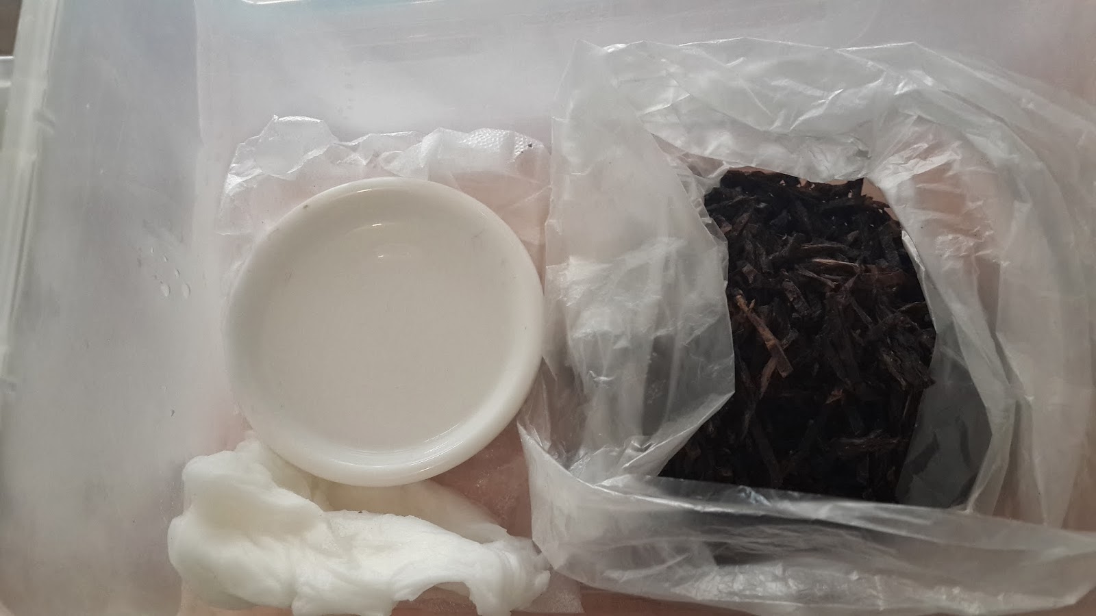 盒内一侧放水碗,另一侧放袋装烟草