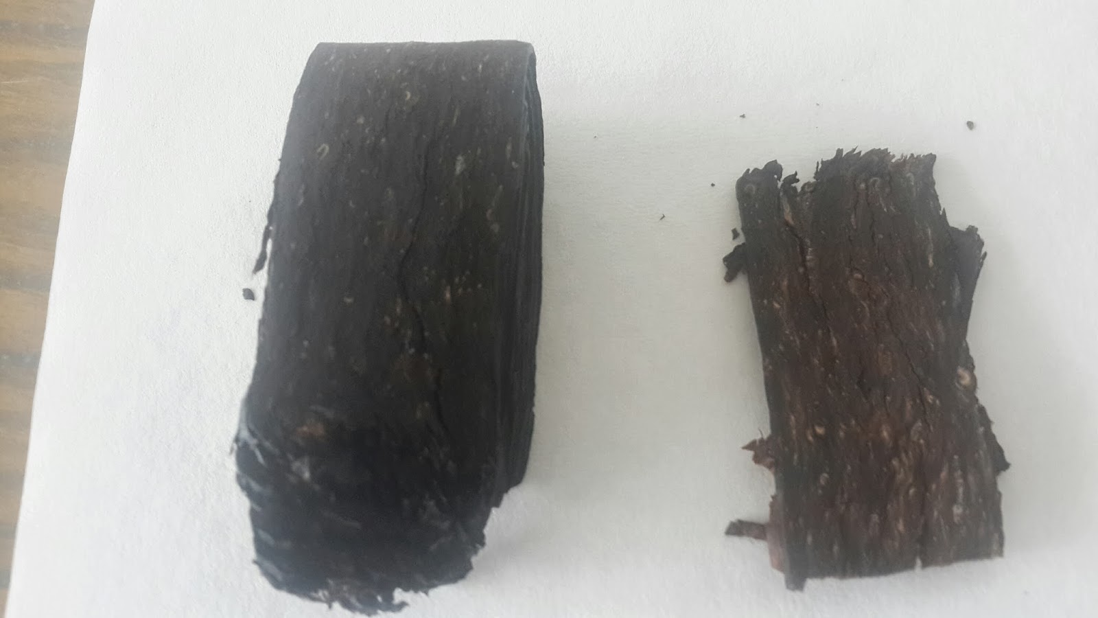 白色纸面上两份颜色深浅不同的压制烟草